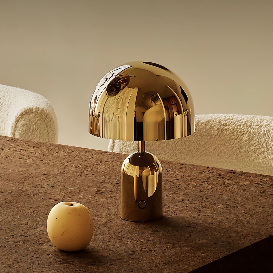 Gold table lamp on a textured surface with a neutral background