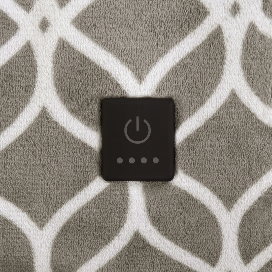 Close-up of taupe heated throw showing built-in power button on white trellis pattern.