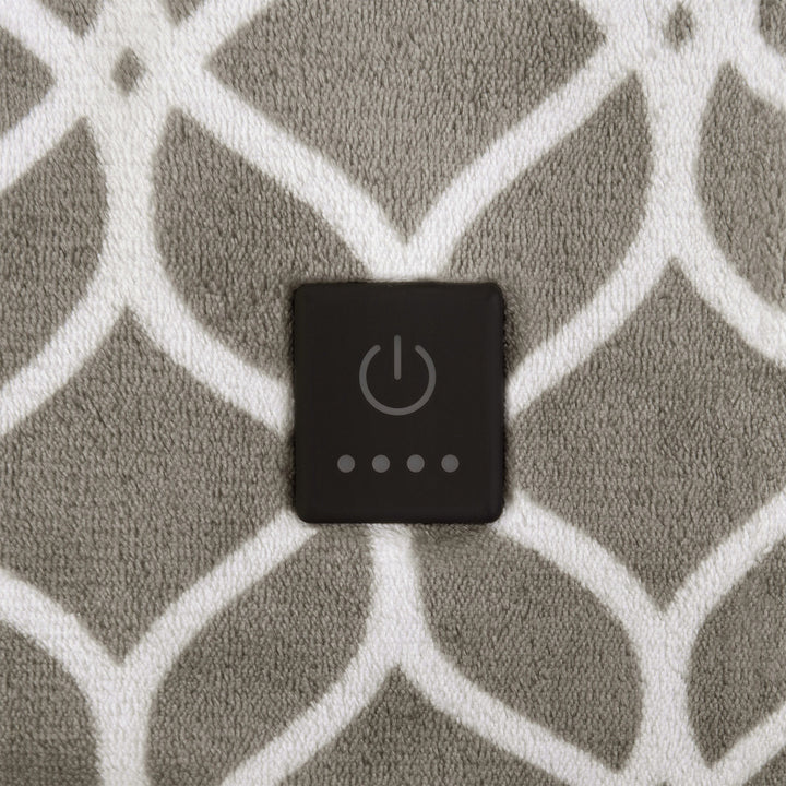 Close-up of taupe heated throw showing built-in power button on white trellis pattern.