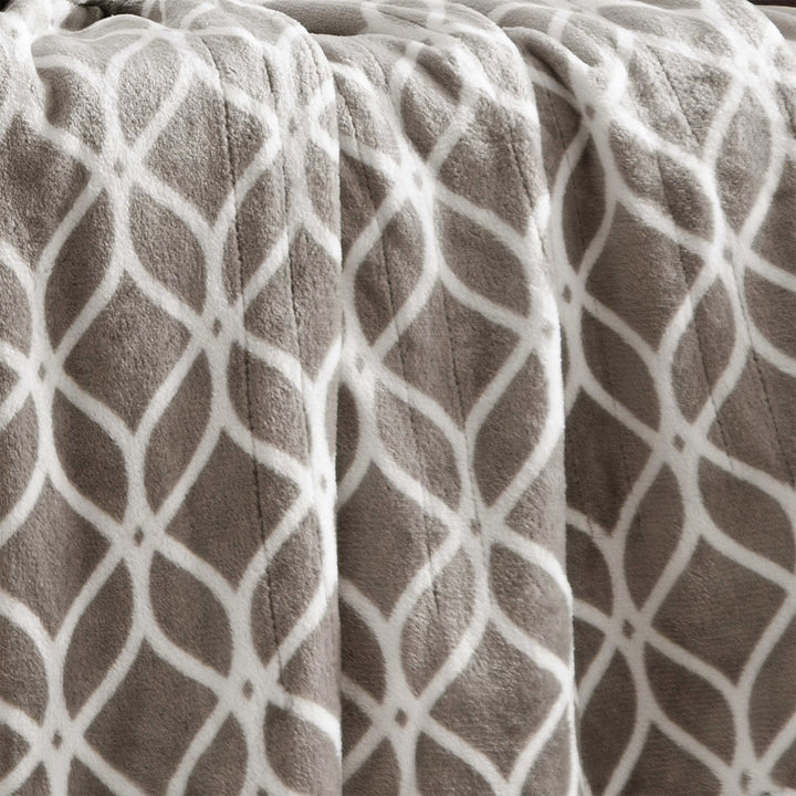 Close-up of taupe heated plush throw with white trellis pattern.