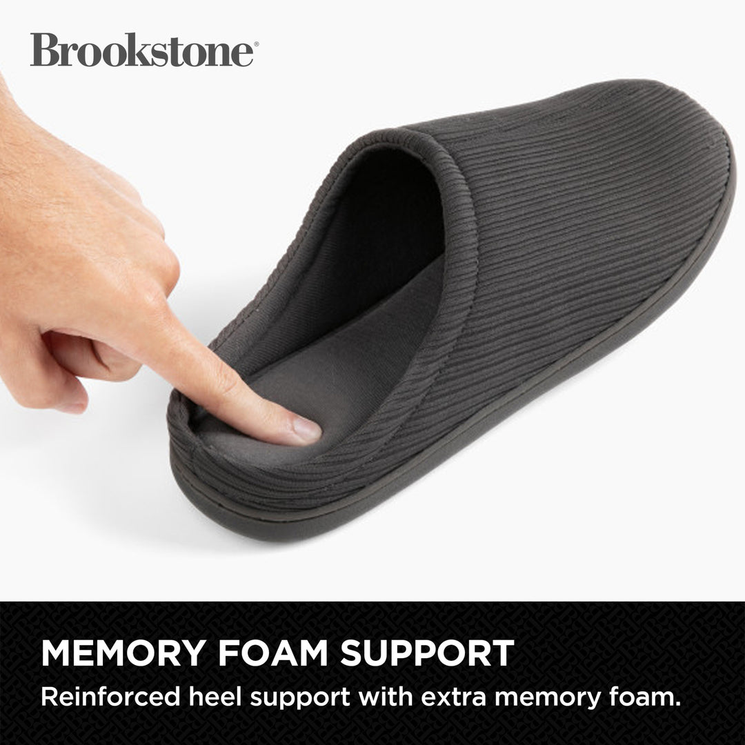 Gray slipper with memory foam support feature, hand pointing to the foam, Brookstone brand visible.