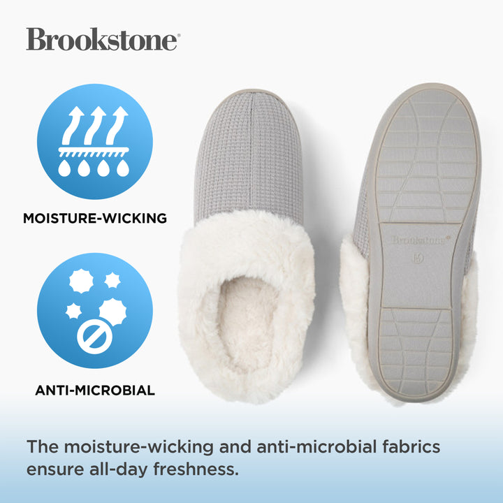 Gray slippers with white lining on a light blue background, featuring Brookstone branding and text about moisture-wicking and anti-microbial properties.