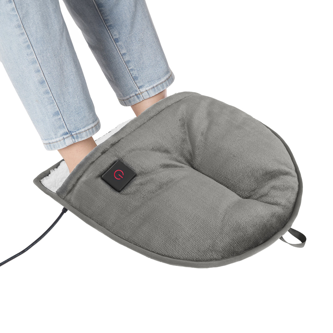 Gray foot warmer being used with a person wearing light blue jeans on a white background