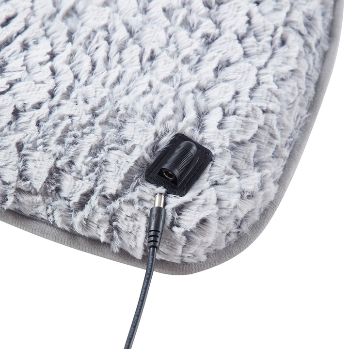 Gray textured heating pad with a plug on a white background