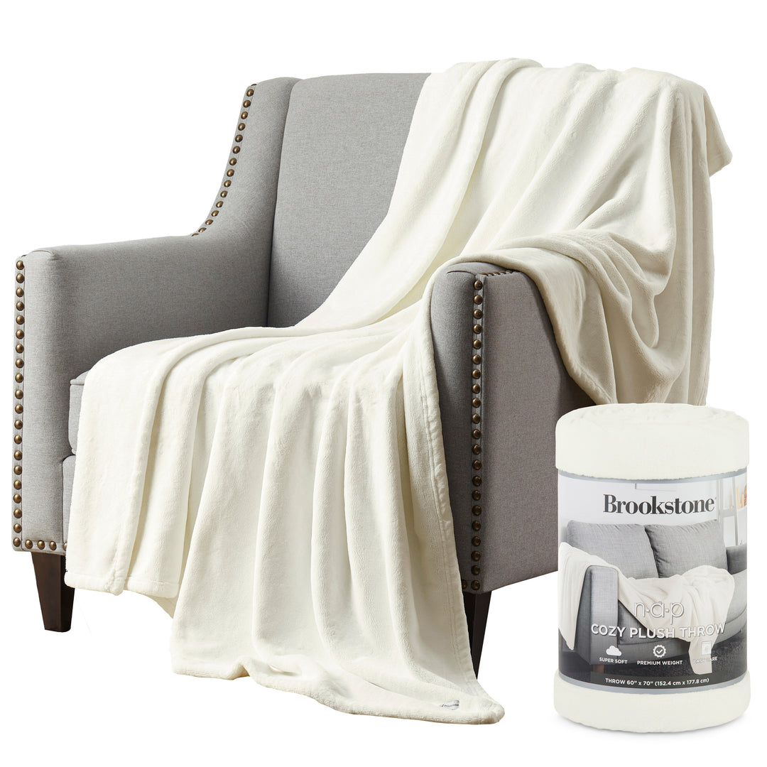 White blanket draped over a gray armchair with a Brookstone product in the foreground.