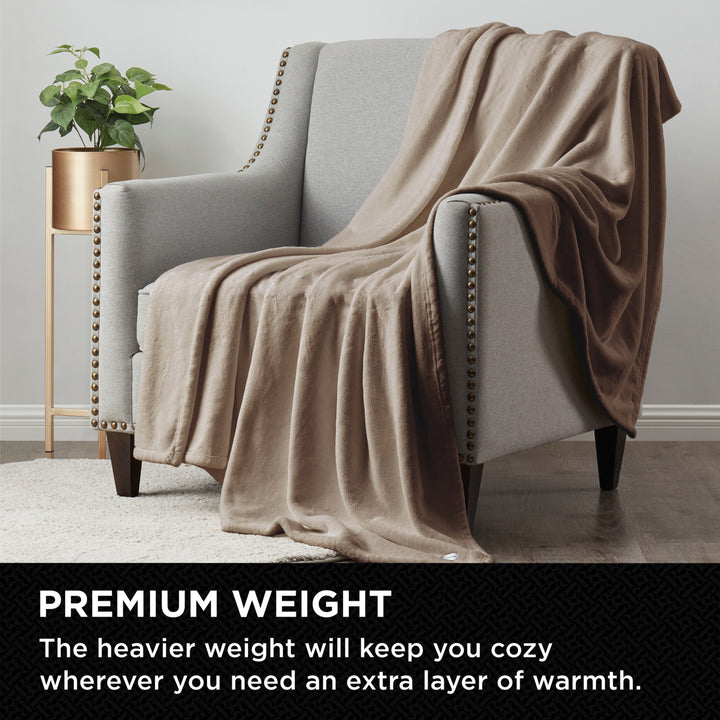 Beige blanket draped over a gray armchair in a cozy living room setting.