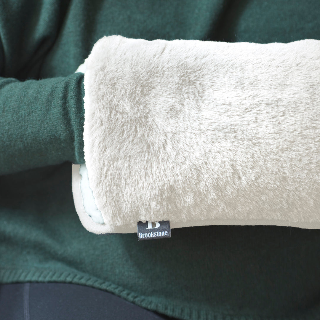Close-up of a green fleece garment with a white hand warmer and Brookstone label.