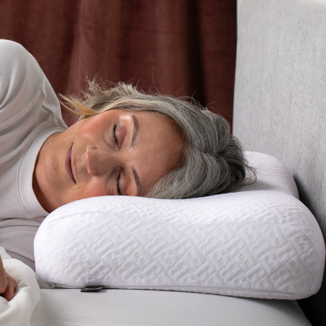 Woman lying on a white pillow with a neutral background