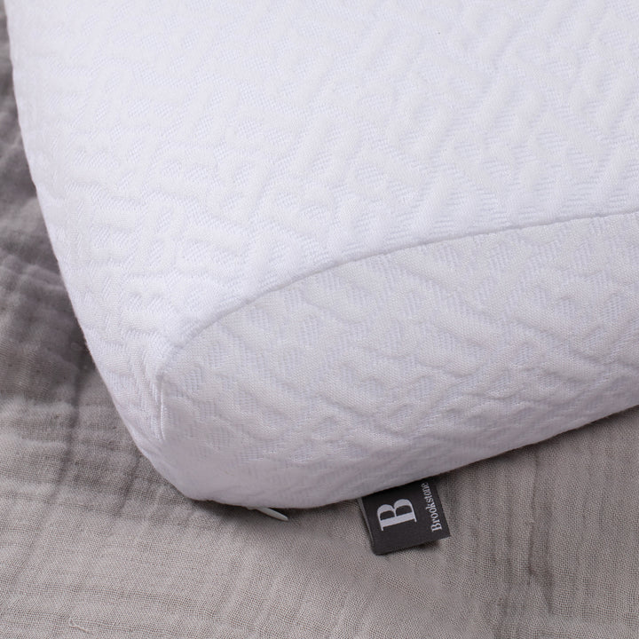 White pillow with a brand tag on a gray fabric background
