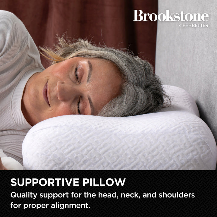 Person lying on a Brookstone supportive pillow with text about quality support.