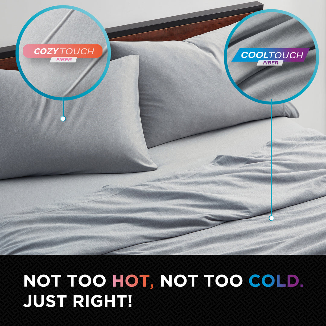 Gray bedding set with Cozy Touch and Cool Touch fiber labels on a bed.