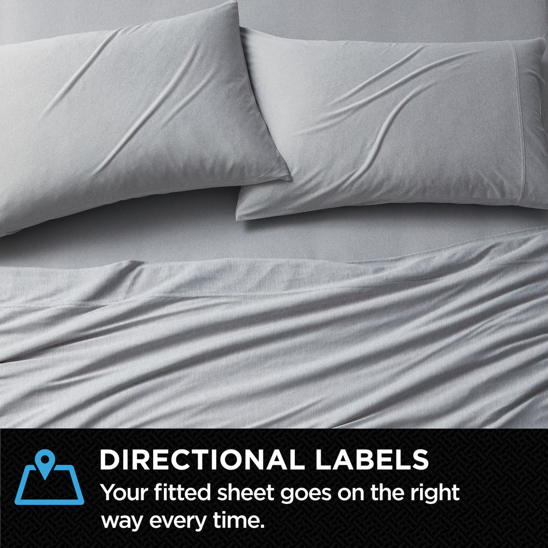Gray fitted sheet and pillowcases on a bed with directional label text.