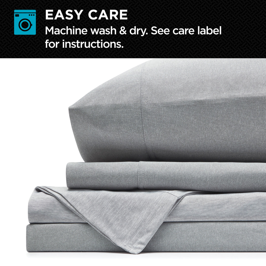 Gray bedding set with folded blanket and pillow on a white background, featuring washing instructions.