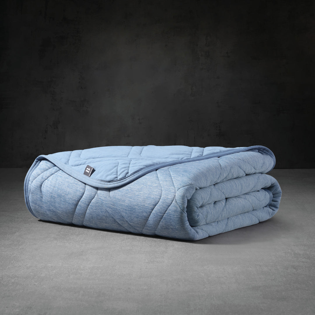 Folded blue weighted blanket on a dark gray background