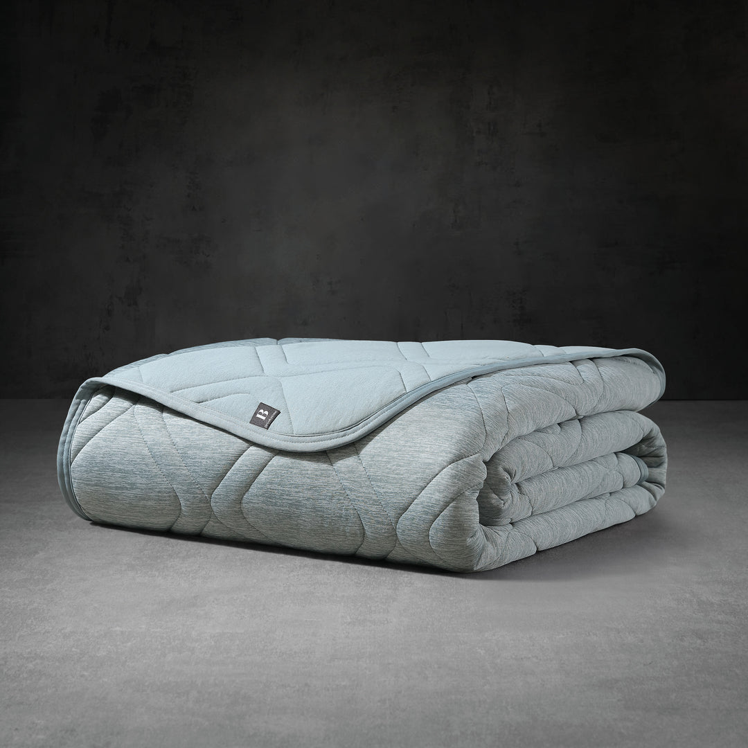 Folded light blue weighted blanket on a dark gray background