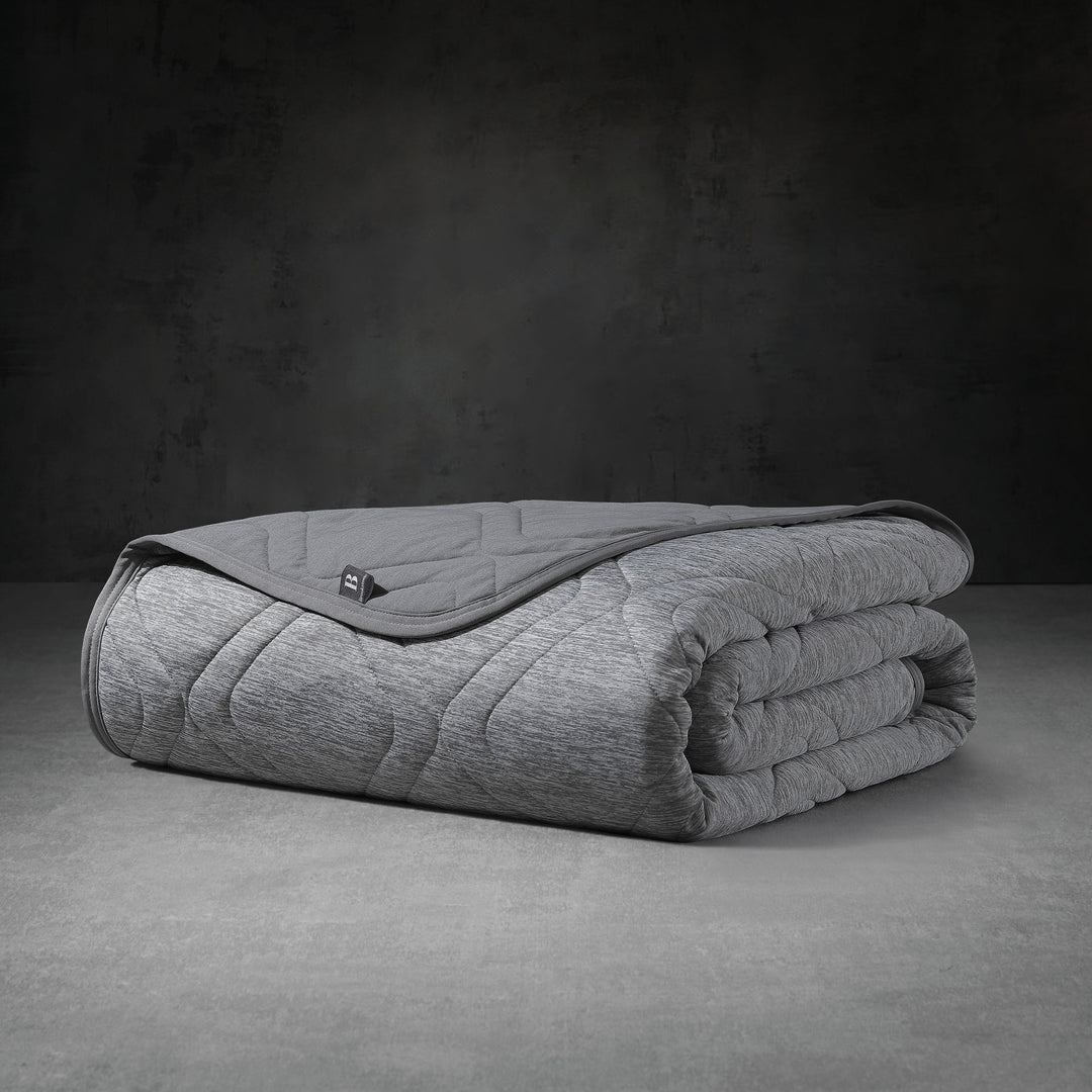 Folded gray weighted blanket on a dark background