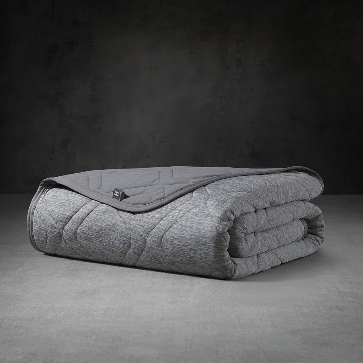 Folded gray weighted blanket on a dark background
