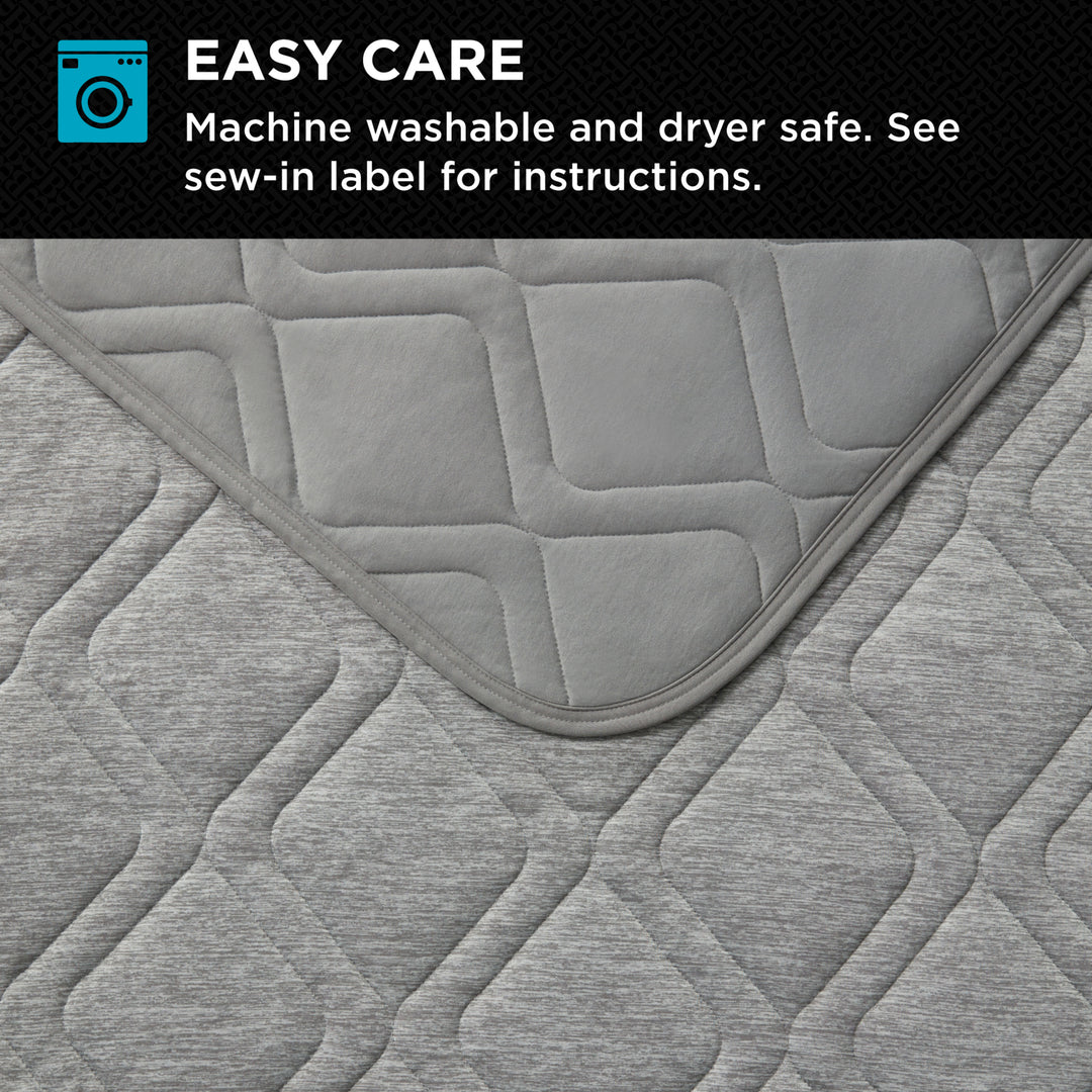 Gray quilted fabric with machine washable and dryer safe text on a black background