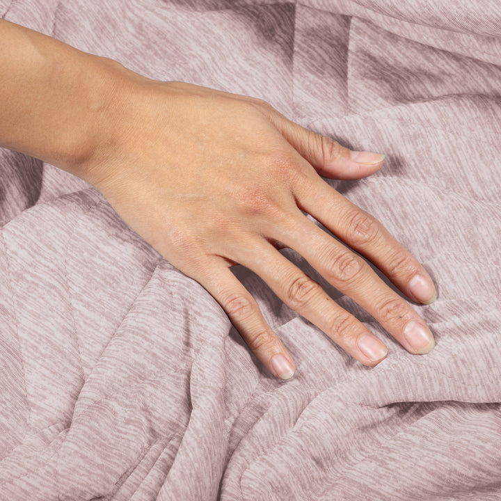 Hand resting on a textured pink fabric surface