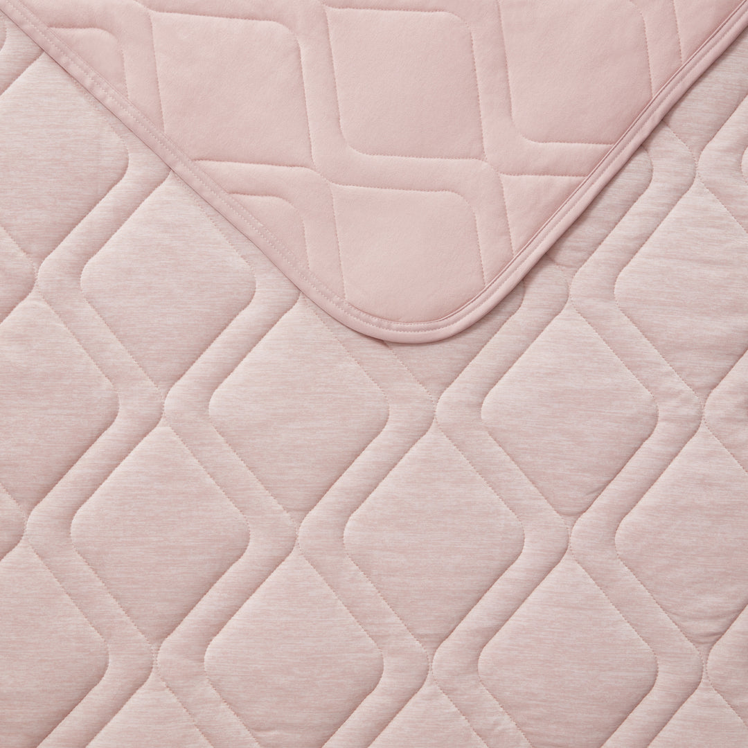 Close-up of a quilted pink fabric with geometric pattern
