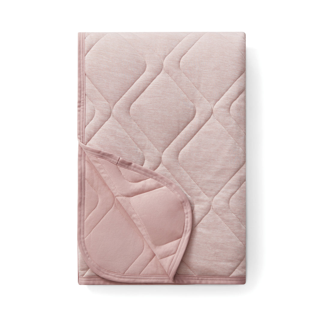 Pink quilted blanket on a white background