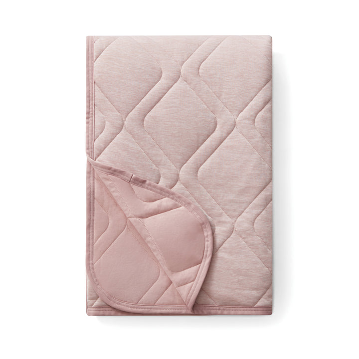 Pink quilted blanket on a white background