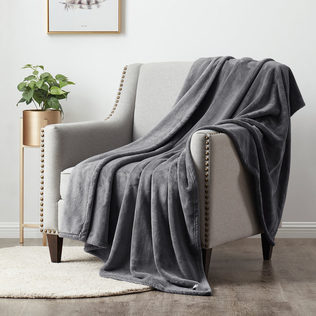Plush Silver throw blanket draped over a modern armchair in a cozy living room setting.