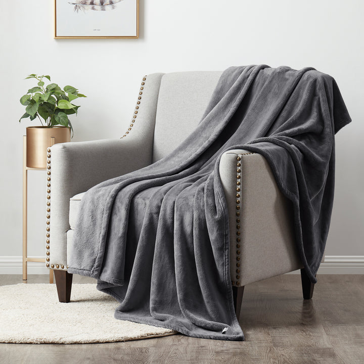 Plush Silver throw blanket draped over a modern armchair in a cozy living room setting.