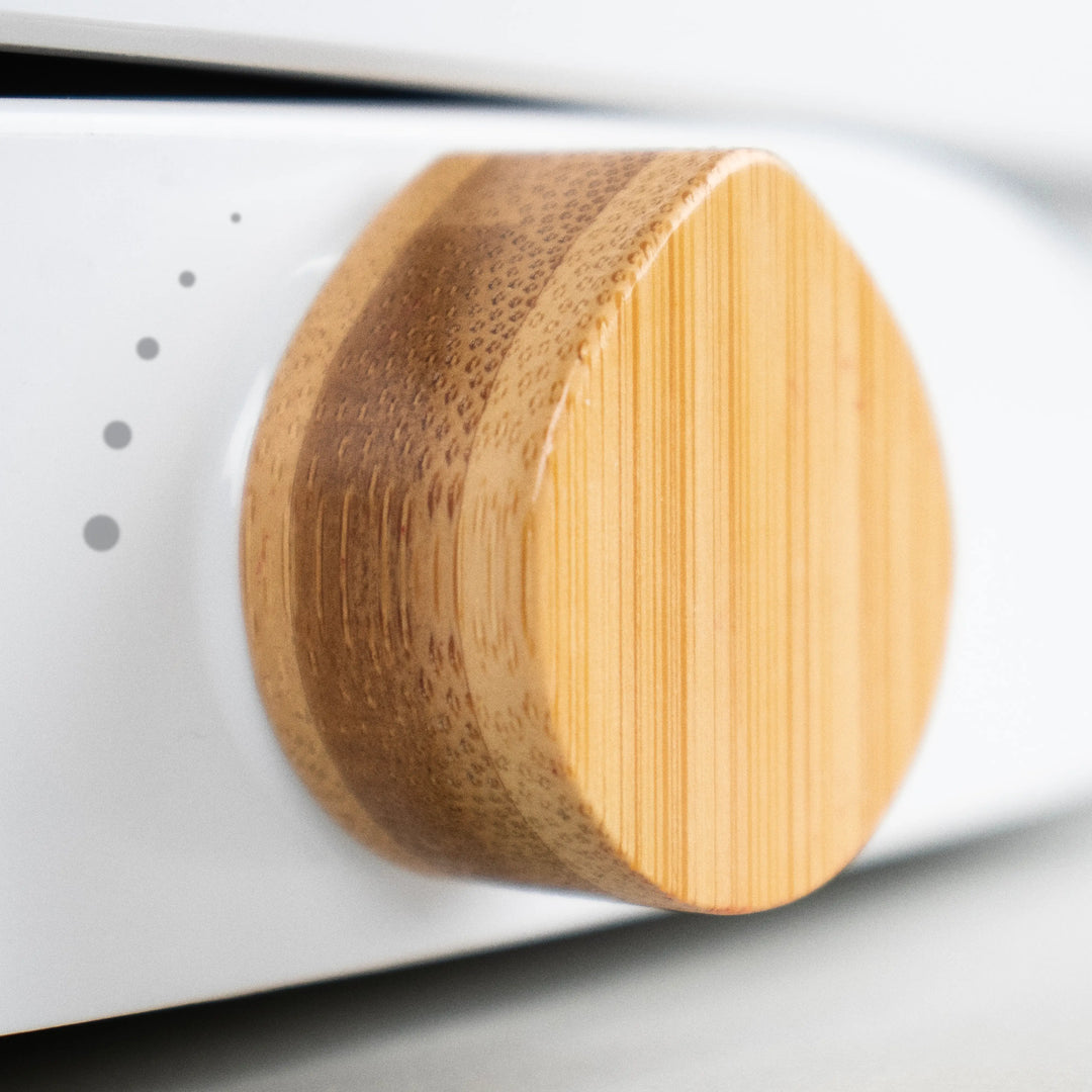 Close-up of a TUSHY Oasis bamboo control knob on a white background