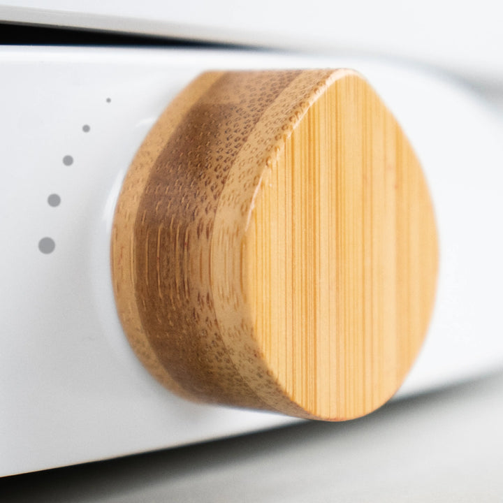 Close-up of a TUSHY Oasis bamboo control knob on a white background
