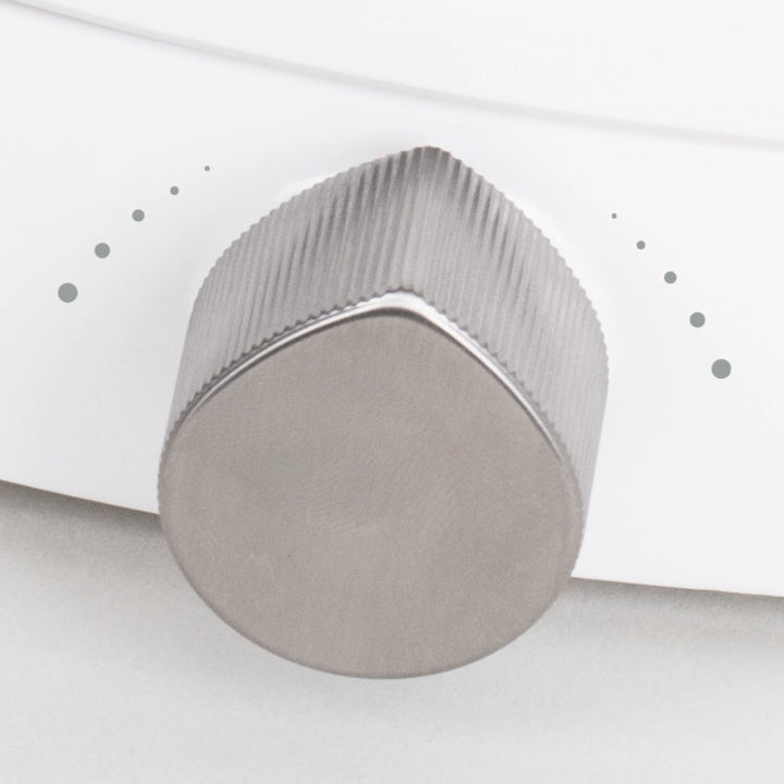 Close-up of a TUSHY Wave, platinum control knob on a white background