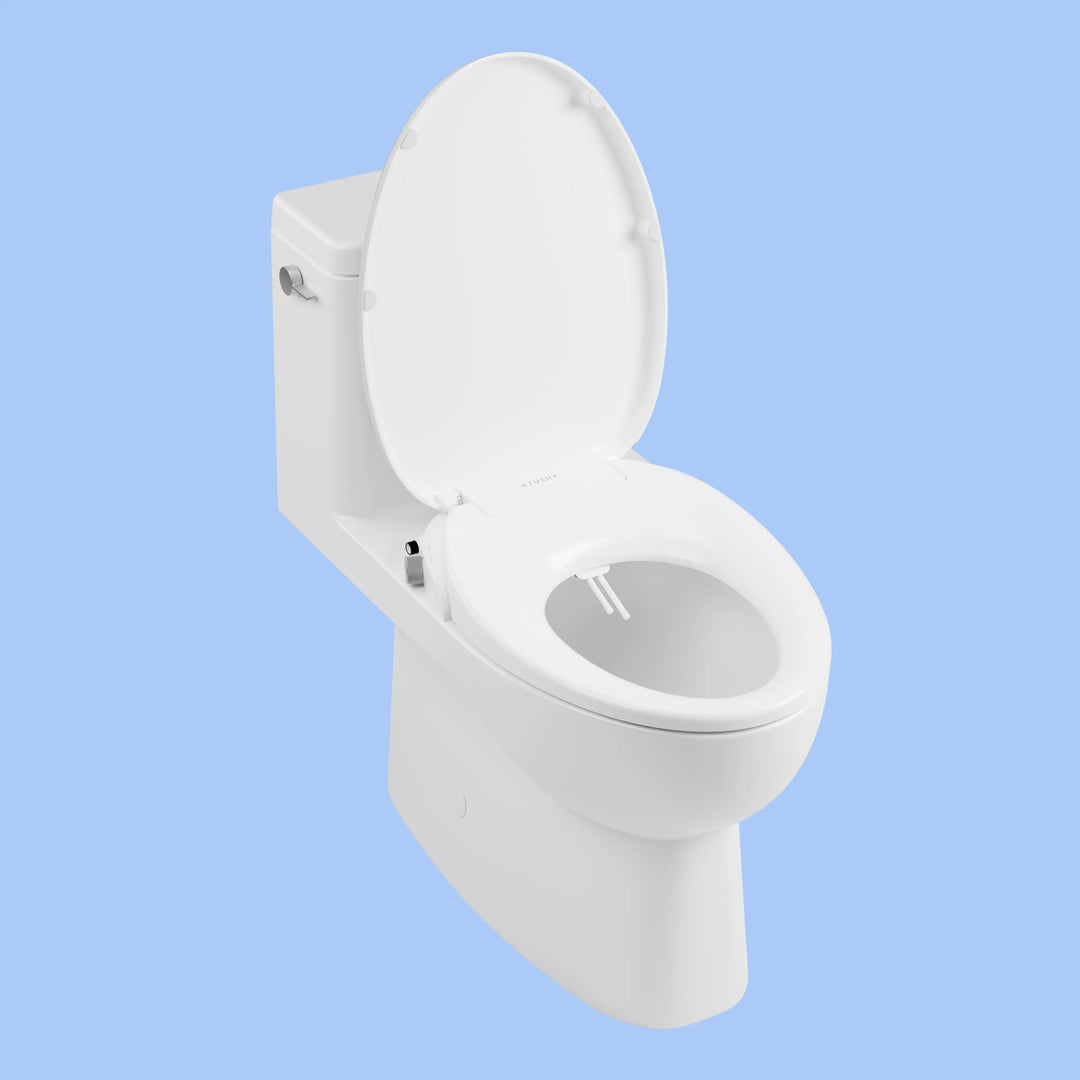 3/4 view of a toilet with a TUSHY Wave bidet seat, lid open, with a platinum control knob, on a blue background 