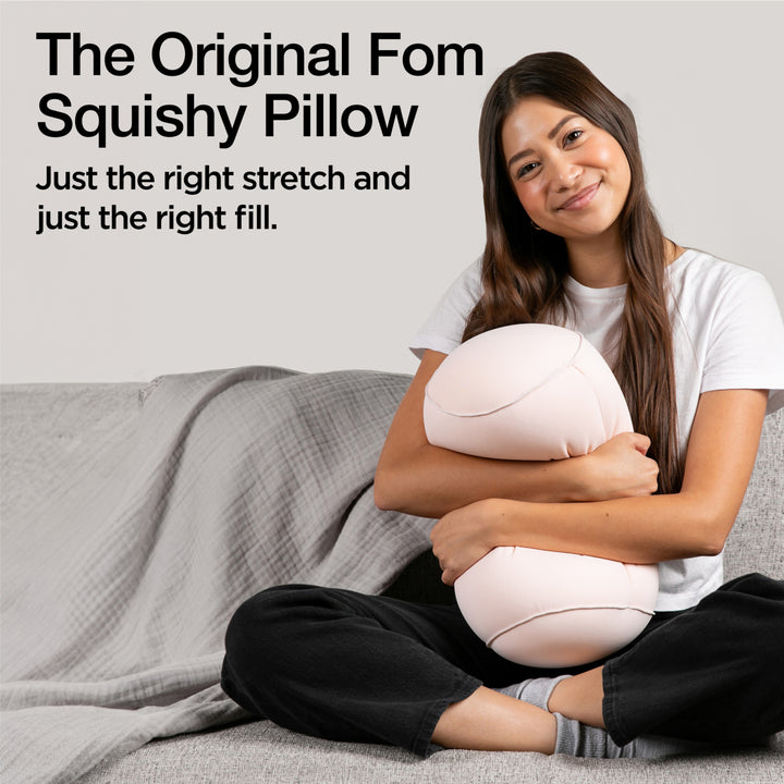 Woman holding a squishy pillow with promotional text on a gray background