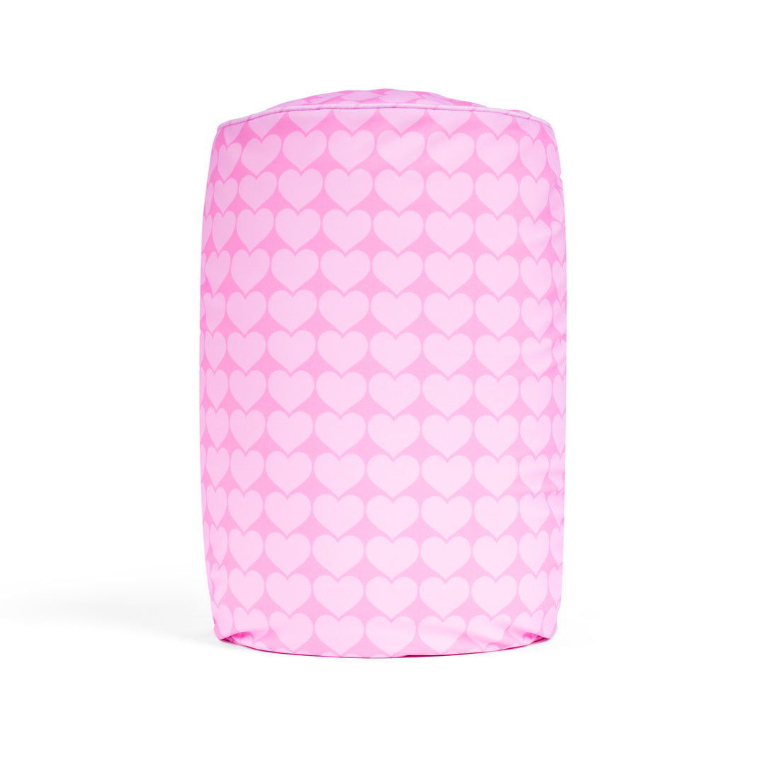 Pink cylindrical pillow with white heart pattern on a white background