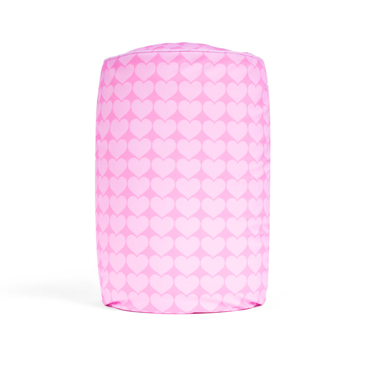 Pink cylindrical pillow with white heart pattern on a white background