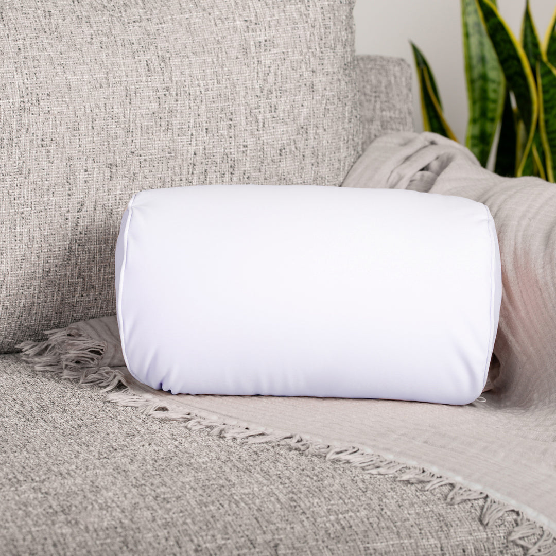 White rolled-up blanket on a textured gray sofa with a plant in the background