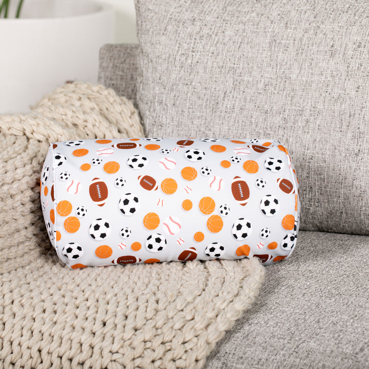 Decorative cylindrical pillow with sports pattern on a couch