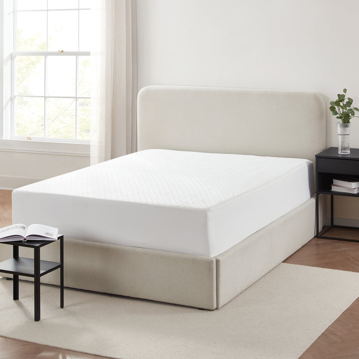 Beige bed frame with white mattress in a room with a window and side table.