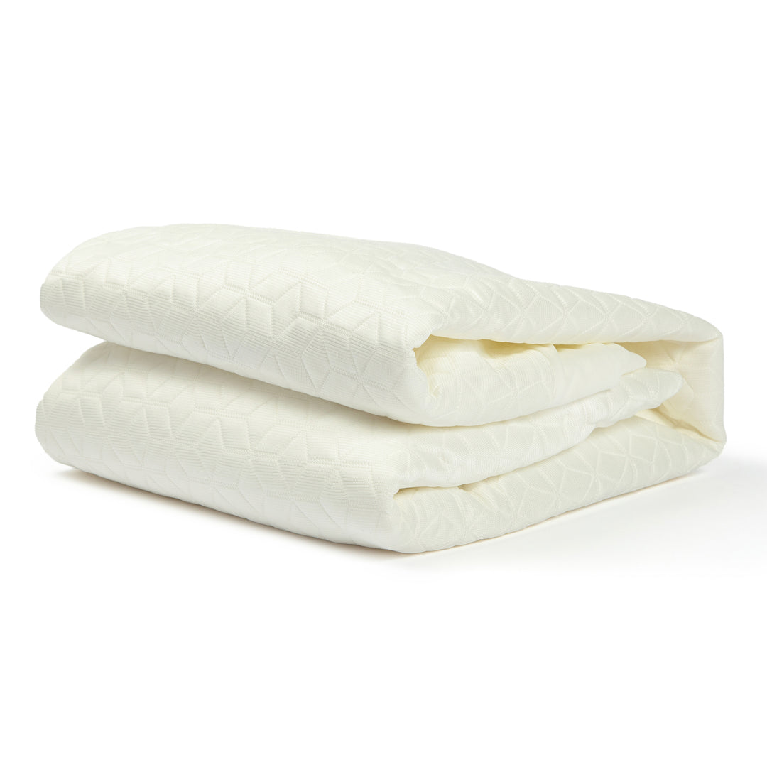 Folded white comforter on a white background