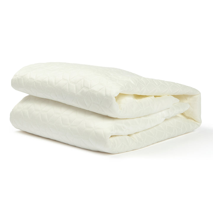 Folded white comforter on a white background