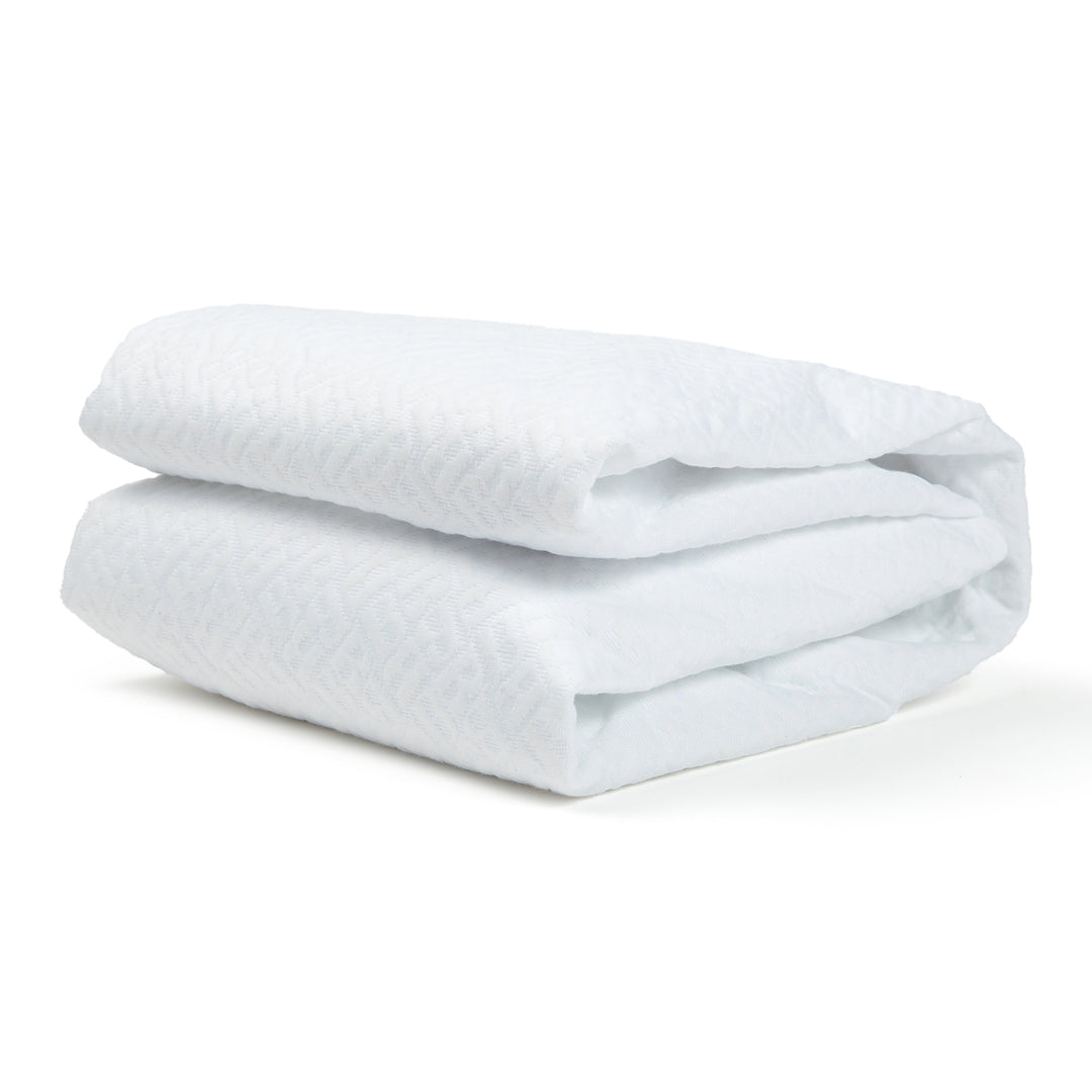 Folded white comforter on a white background