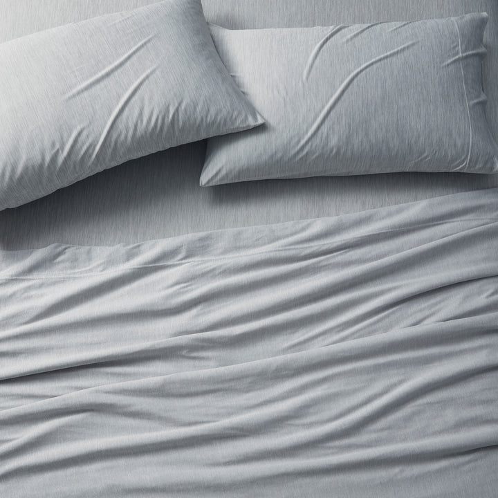 Gray bedding set with two pillows on a bed.