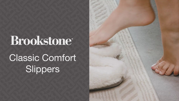 Video showing a person stepping into soft, plush Brookstone Classic Comfort Slippers, highlighting the cozy texture and easy slip-on design.