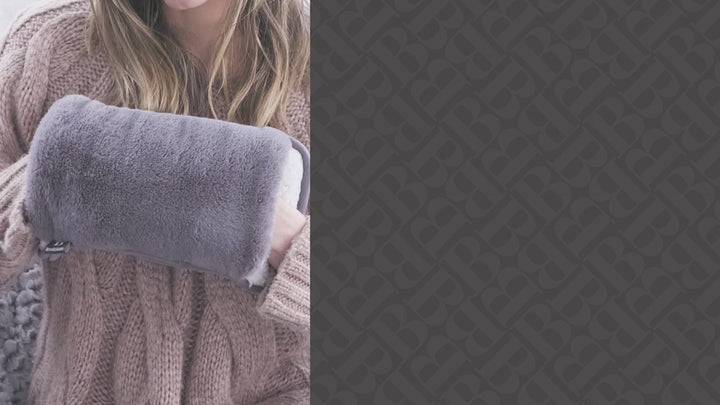 Video showing a person sliding their hands into a plush, ultra-soft Brookstone Snuggly Hand Warmer, highlighting its cozy texture and warming comfort.