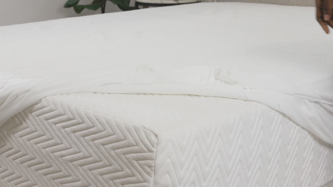 Video demonstrating a waterproof mattress protector being stretched and fitted over a mattress, showing how it fully encloses and protects the surface.